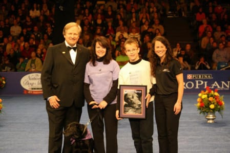 A photo of the winners with their dog and the host